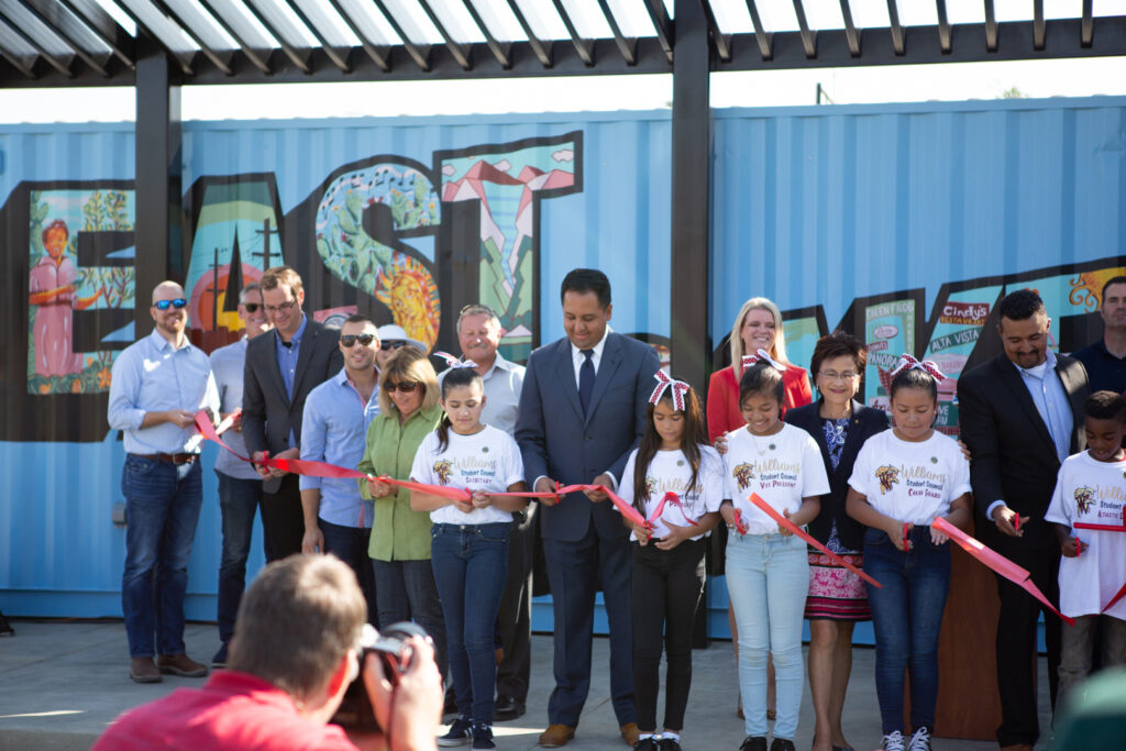 a group of people cutting a ribbon